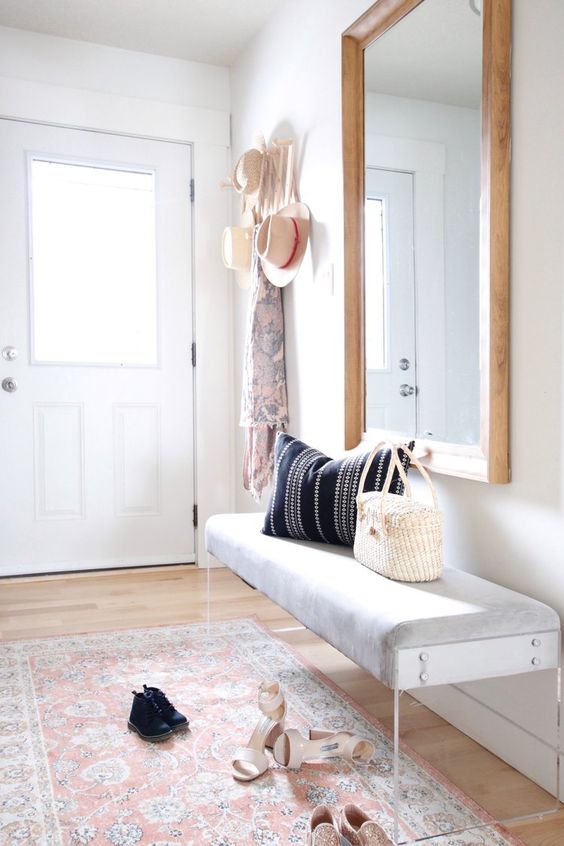 airy entryway with a modern bench ans a large mirror