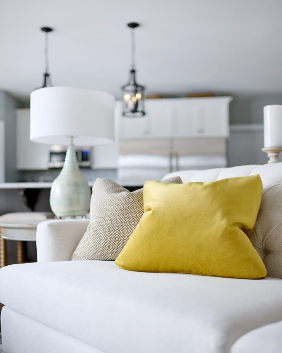 Bright throw cushions on a sofa with a kitchen in the background, interior designer Ottawa, interior design Ottawa